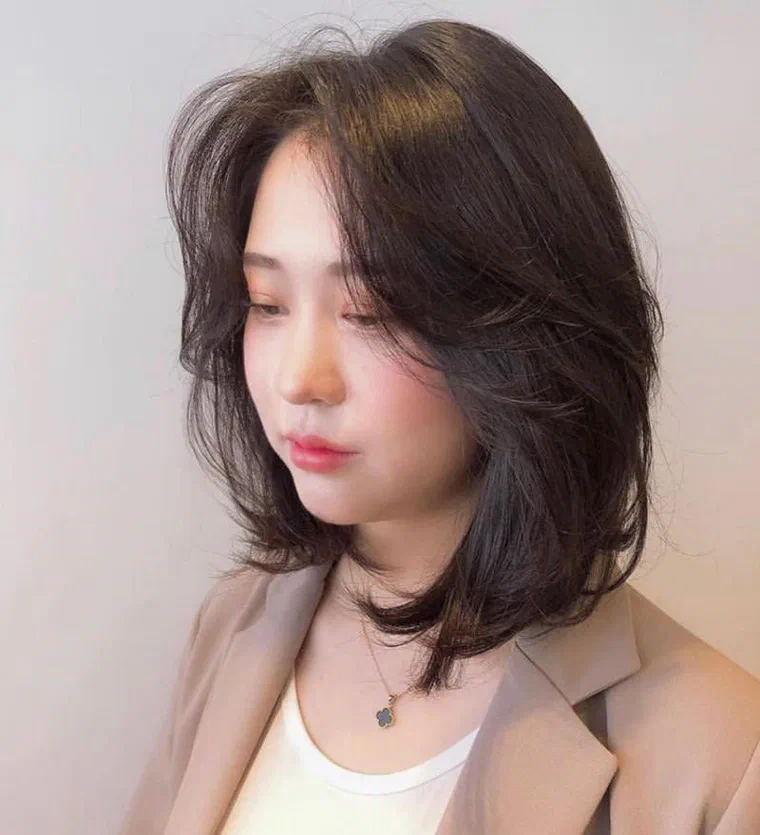 Cô gái tóc nâu đen độ dài lỡ ngang cằm, tầng cao ở đỉnh và ngọn tỉa vát bồng