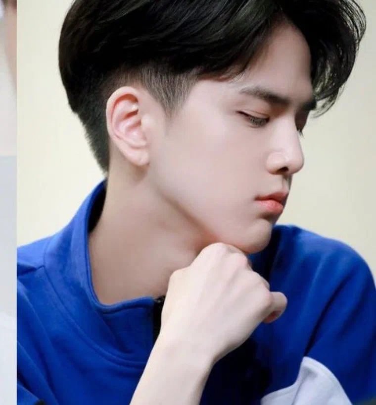 Nam giới nhìn nghiêng cúi xuống, hai bên cạo ngắn sát, phần đỉnh để dài vuốt chéo