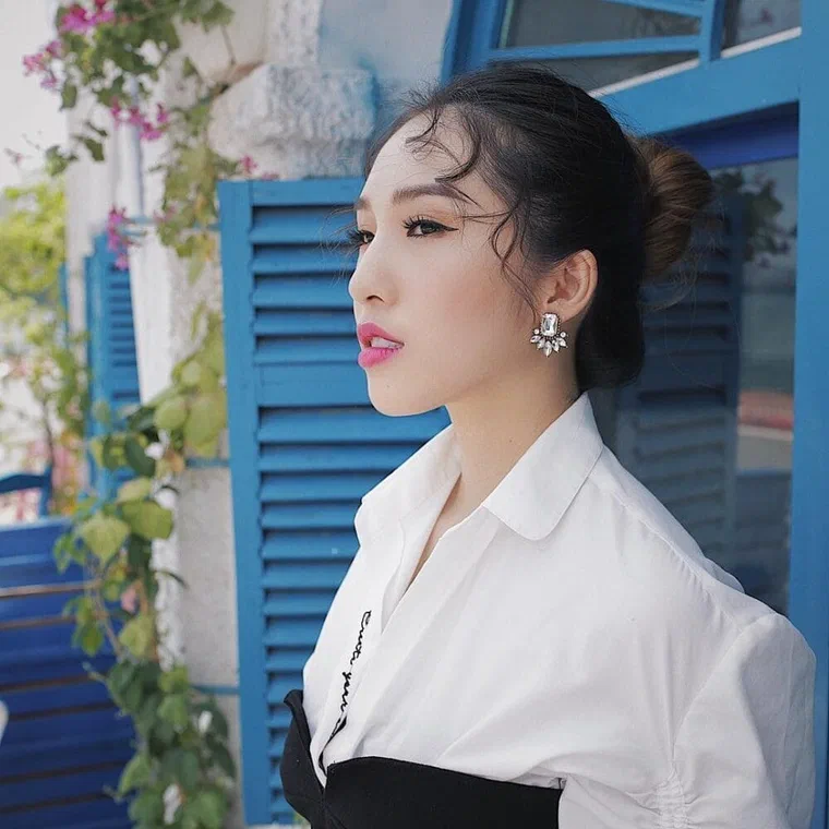 Emily nhìn nghiêng, tóc nâu tối búi thấp sau gáy, vài sợi mai xoăn rơi xuống trước tai