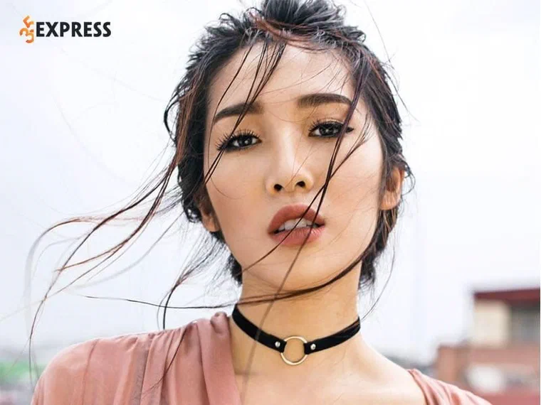 Emily với tóc nâu tối vuốt ngược ướt ra sau, vài sợi mảnh rơi chéo qua mặt