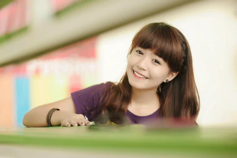 Mẫn Tiên tóc nâu hạt dẻ thẳng dài qua vai, mái bằng dày chạm lông mày, một lọn tết nhỏ chạy dọc bên mai