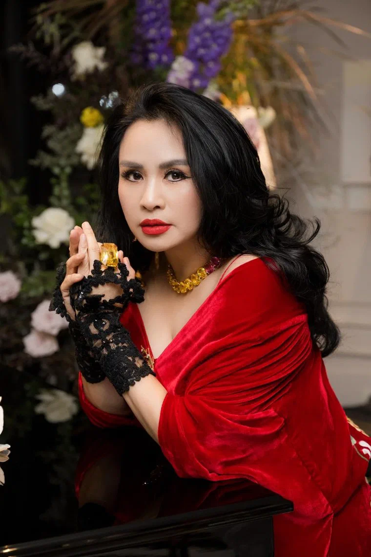 Thanh Lam với tóc đen dài quá vai, xoăn lọn to rõ từng lọn, rẽ ngôi lệch sâu, mái dài ôm một bên má