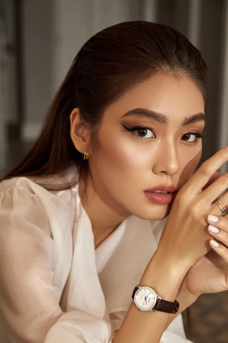 Thảo Nhi Lê tóc dài nâu đen vuốt ngược toàn bộ ra sau, bóng mượt sát da đầu, áo sơ mi trắng mỏng